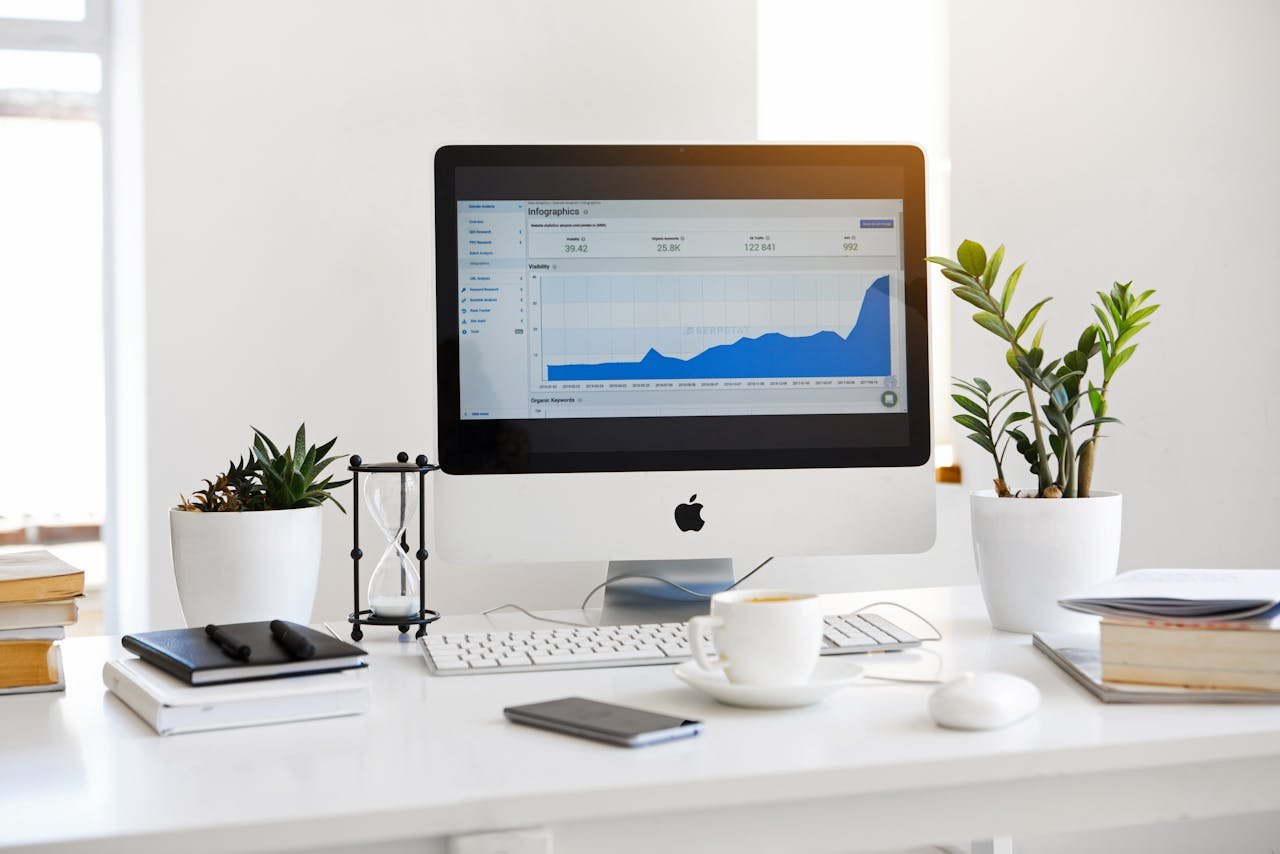 about-03 A clean, contemporary workspace featuring a desktop with analytics on the screen and plants for a fresh look.
